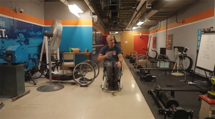 Researcher Adam Bleakney demonstrates the hands-free wheelchair